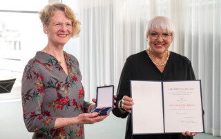 Sabine Wüsthoff erhält das Bundesverdienstkreuz von Claudia Roth, Staatsministerin für Kultur und Medien